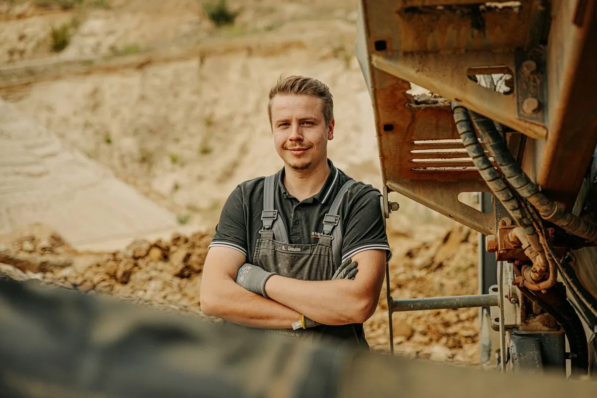 Monteur mit verschränkten Armen vor einer Anlage